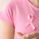 "Person wearing a pink breast cancer awareness ribbon representing recovery and rehabilitation after breast cancer treatment.